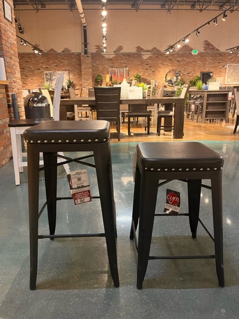 Two black farm house barstools, one at bar height and the other at counter height 